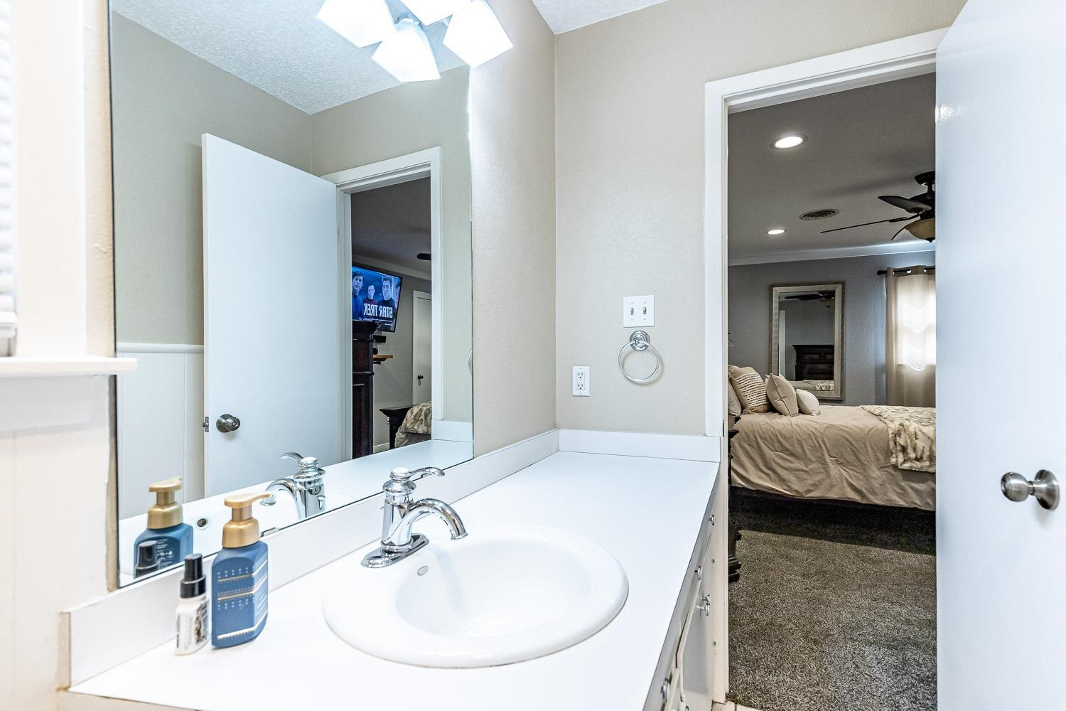 3604 48th Street Lubbock, TX 79413 - Photo 25 of 50 a en suite bathroom with a double vanity sink and mirror