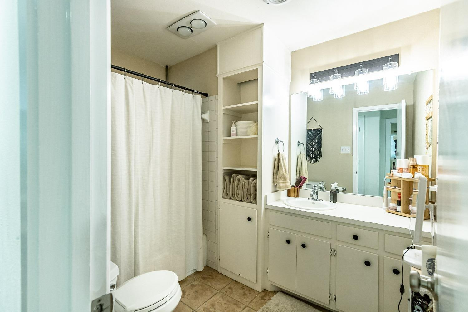 3604 48th Street Lubbock, TX 79413 - Photo 29 of 50 a bathroom with a double vanity sink toilet and shower
