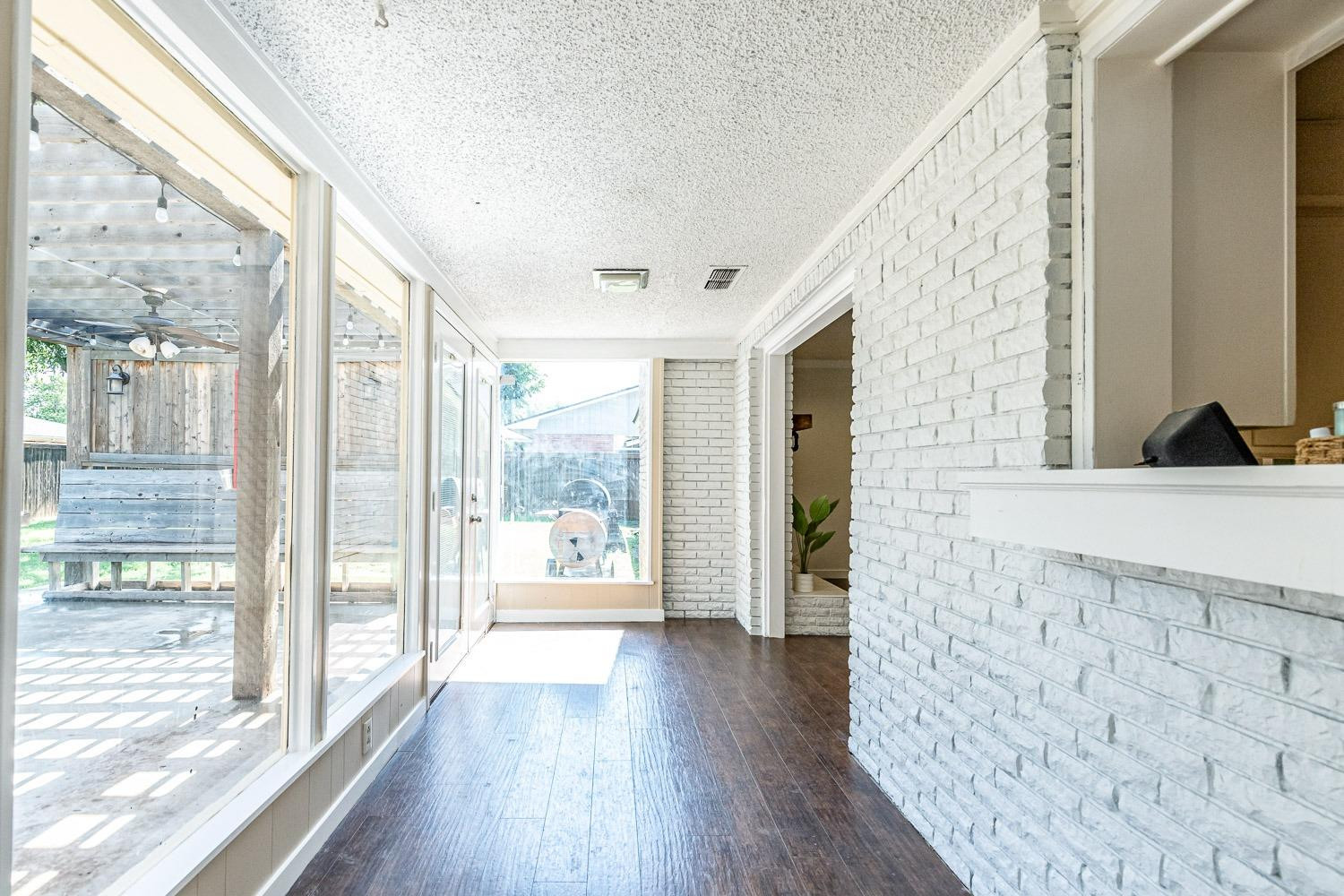3604 48th Street Lubbock, TX 79413 - Photo 36 of 50 a view of a living room with wooden floor and a floor to ceiling window
