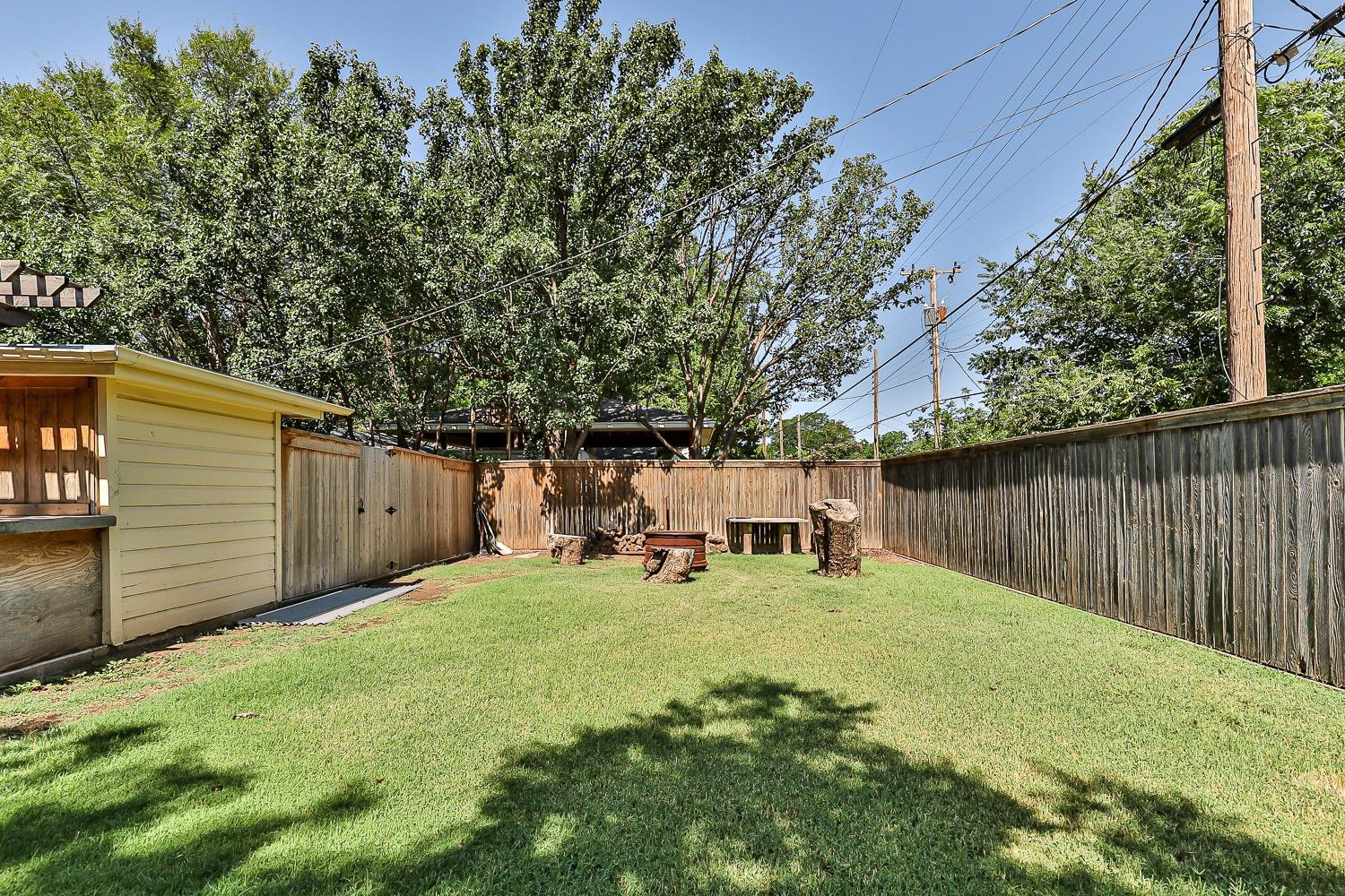 3604 48th Street Lubbock, TX 79413 - Photo 42 of 50 a view of a backyard with table and chairs and wooden fence