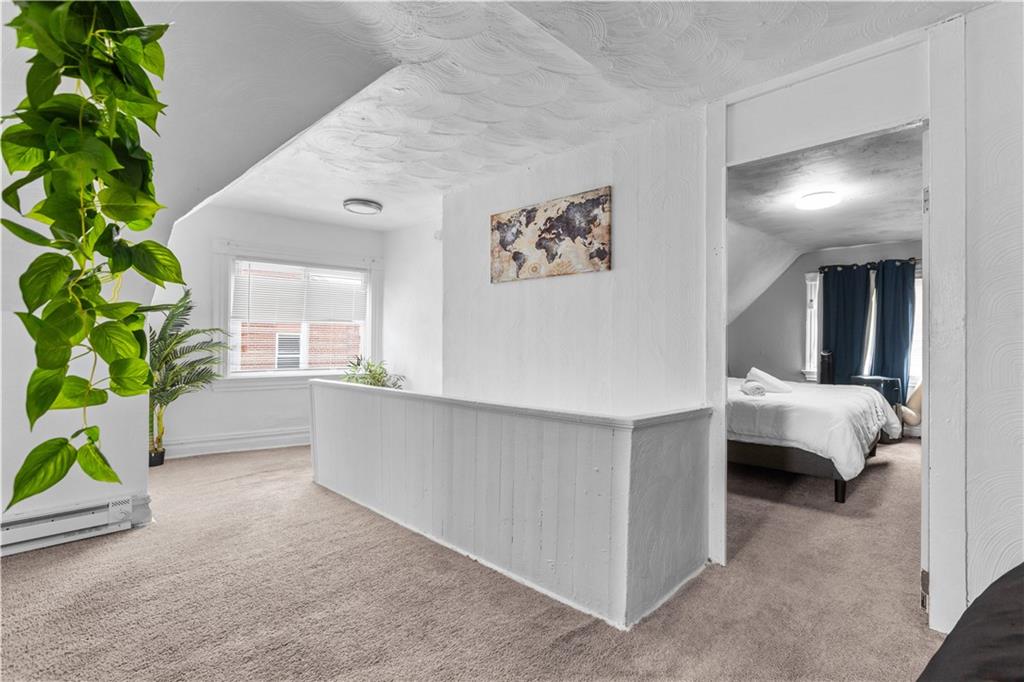 17 Lelia Street Pittsburgh, PA 15211 - Photo 14 of 26 a room with a bed and a potted plant