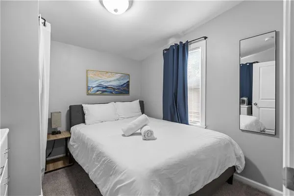 a bedroom with a large bed and a chandelier