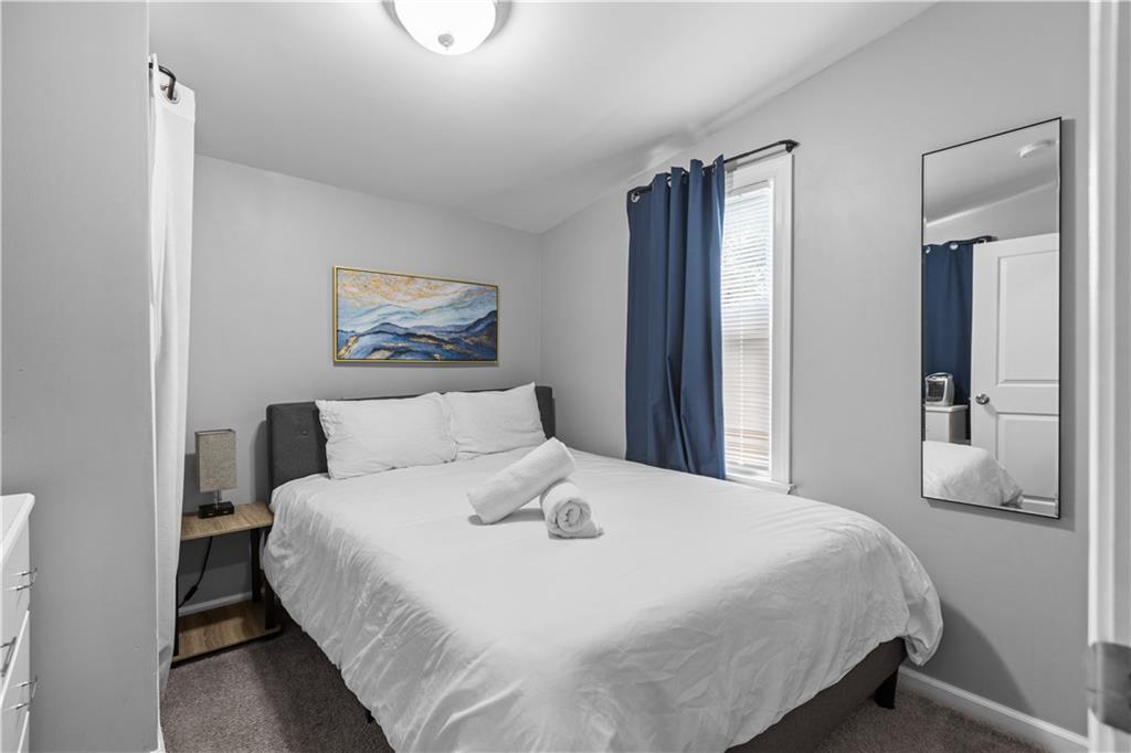 17 Lelia Street Pittsburgh, PA 15211 - Photo 22 of 26 a bedroom with a large bed and a chandelier