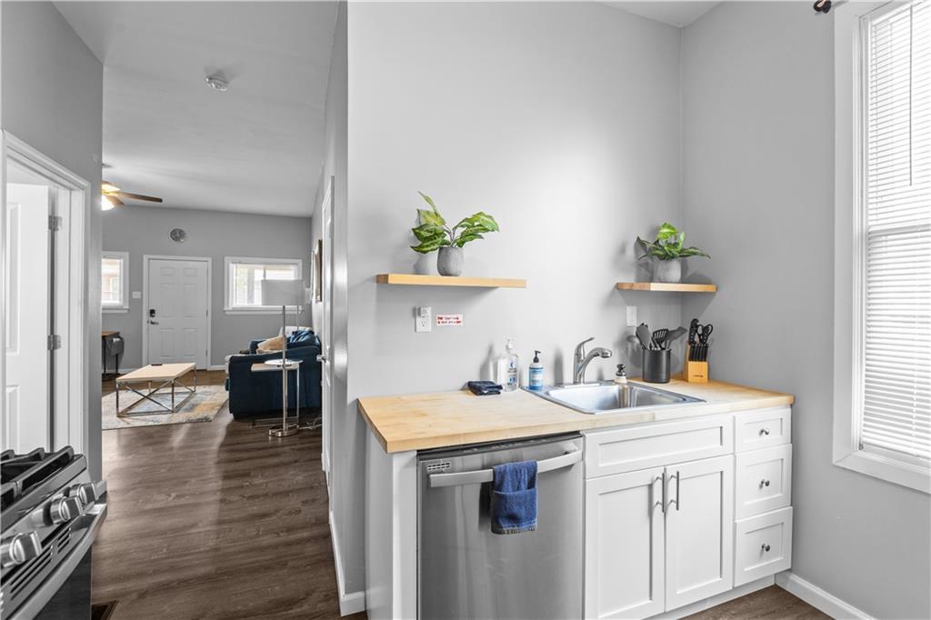 17 Lelia Street Pittsburgh, PA 15211 - Photo 23 of 26 a kitchen that has a sink and a stove with wooden floor