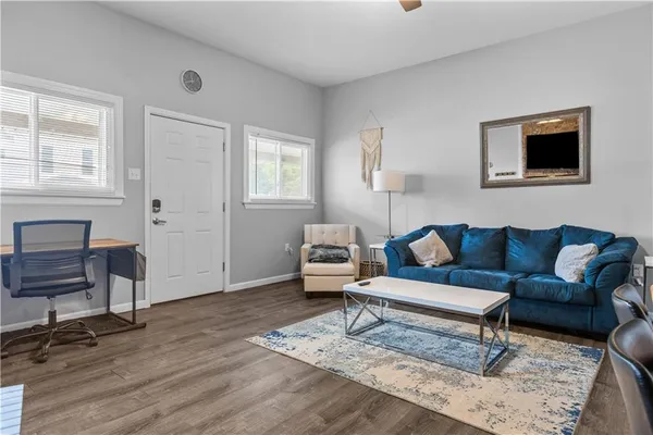 a living room with furniture and a wooden floor
