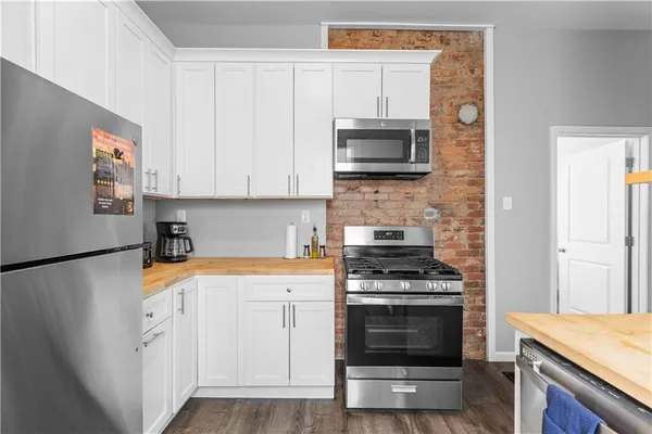 a kitchen with white cabinets and stainless steel appliances