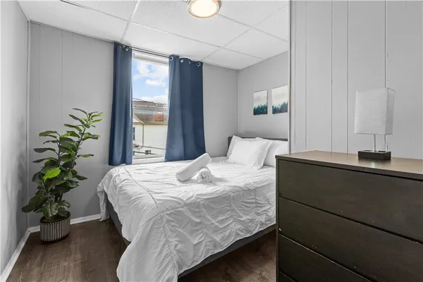 a bedroom with a bed window and wooden floor