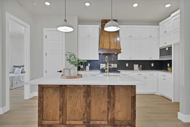 a view of a kitchen with granite countertop a sink stainless steel appliances and cabinets