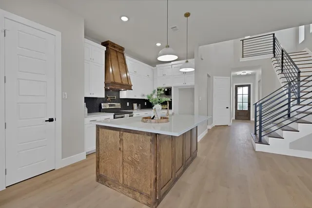 a kitchen with stainless steel appliances kitchen island a sink cabinets and wooden floor