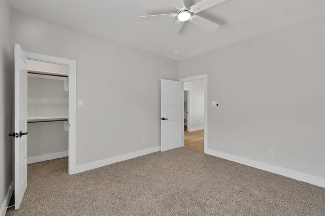 a view of an empty room with a ceiling fan