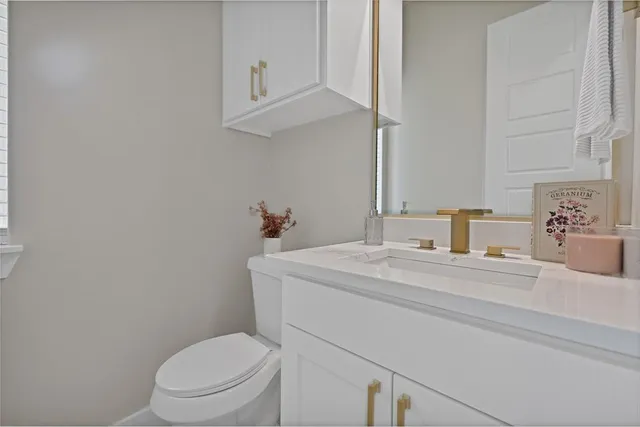 a bathroom with a sink a toilet and vanity