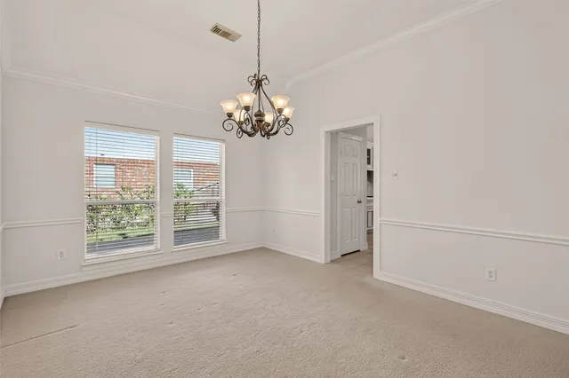 a view of a livingroom with a chandelier a ceiling fan and windows