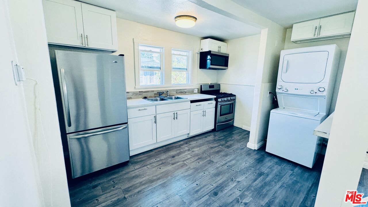 219 East 10th Street Long Beach, CA 90813 - Photo 3 of 26 a kitchen with stainless steel appliances a refrigerator sink and wooden floor