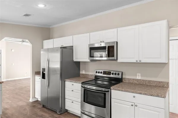 a kitchen with white cabinets and stainless steel appliances