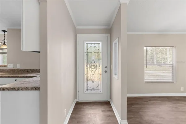 a view of hallway with window and wooden floor