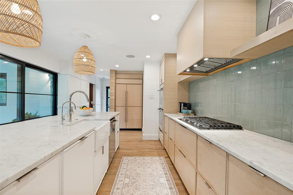 4325 Pomona Road Dallas, TX 75209 - Photo 11 of 25 Bright kitchen featuring light wood-finish flooring, white countertop surfaces, and a tiled backsplash