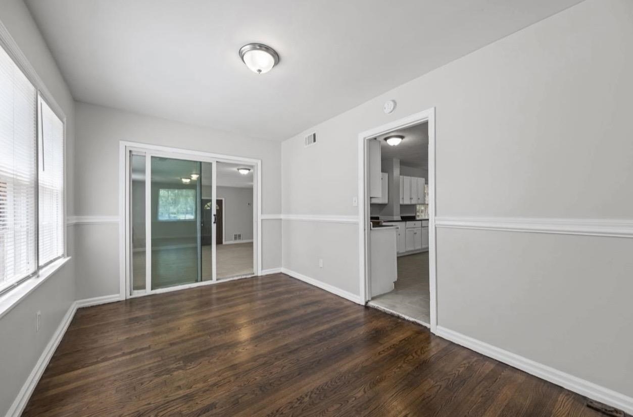 3843 Blue Jay Road Memphis, TN 38116 - Photo 8 of 23 an empty room with wooden floor and windows
