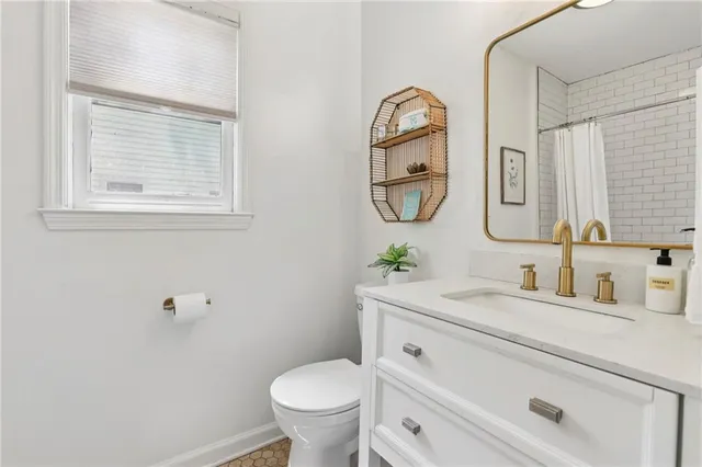 a bathroom with a toilet sink and mirror