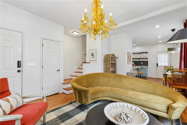 a bedroom with a bed a couch and a chandelier