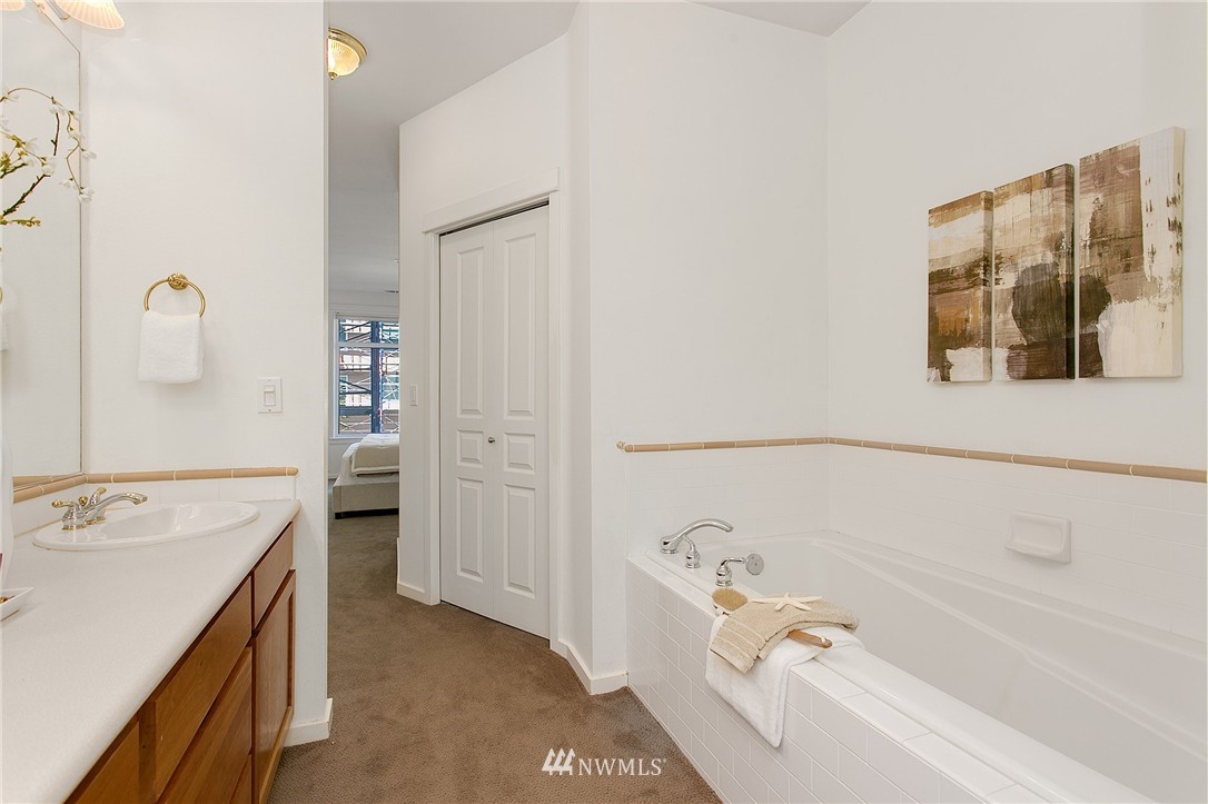1950 Alaskan Way, Unit 237 Seattle, WA 98101 - Photo 14 of 20 a bathroom with a tub a sink and a window