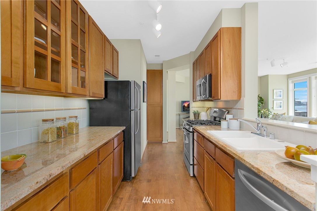 1950 Alaskan Way, Unit 237 Seattle, WA 98101 - Photo 6 of 20 a kitchen with stainless steel appliances granite countertop a sink stove and refrigerator