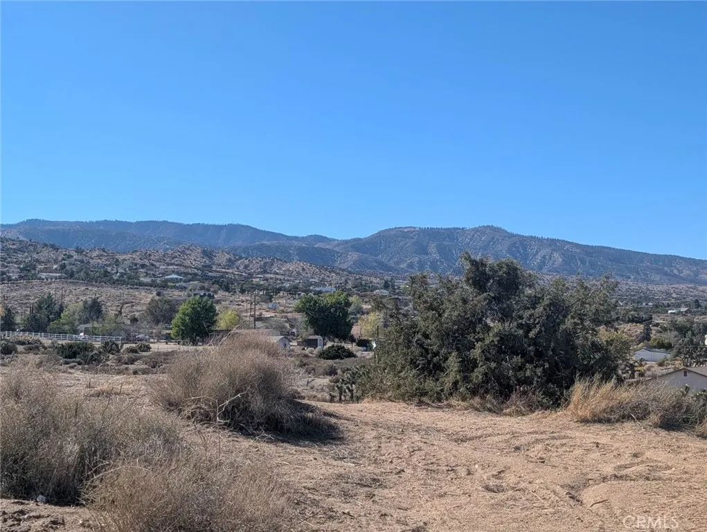 0 Malpaso Road Phelan, CA 92371 - Photo 5 of 19 a view of a dry field with mountains in the background