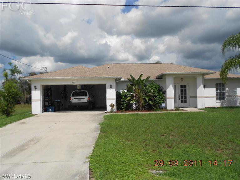 217 Rue Labonne Road Fort Myers, FL 33913 - Photo 1 of 8 a front view of a house with a garden and yard