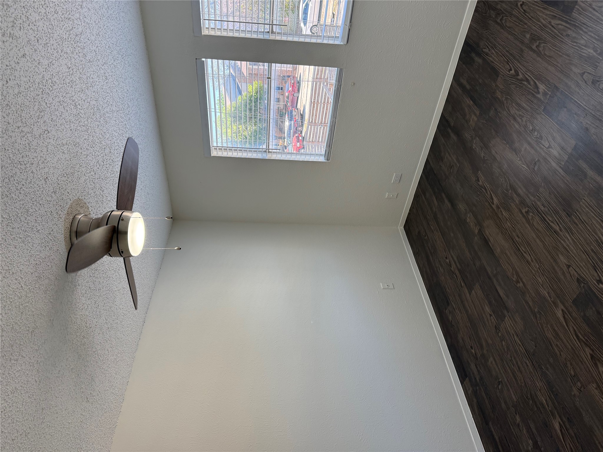 11807 Alpheus Avenue, Unit B Austin, TX 78759 - Photo 12 of 16 Spare room with a textured ceiling, dark wood-style floors, and a ceiling fan