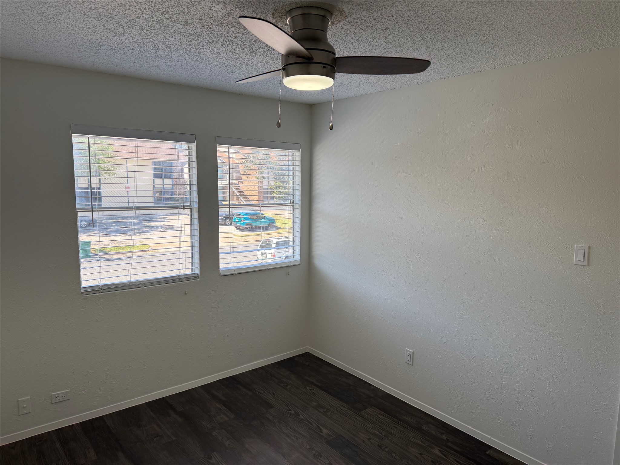 11807 Alpheus Avenue, Unit B Austin, TX 78759 - Photo 13 of 16 Empty room with a textured ceiling, dark wood-style floors, and a ceiling fan