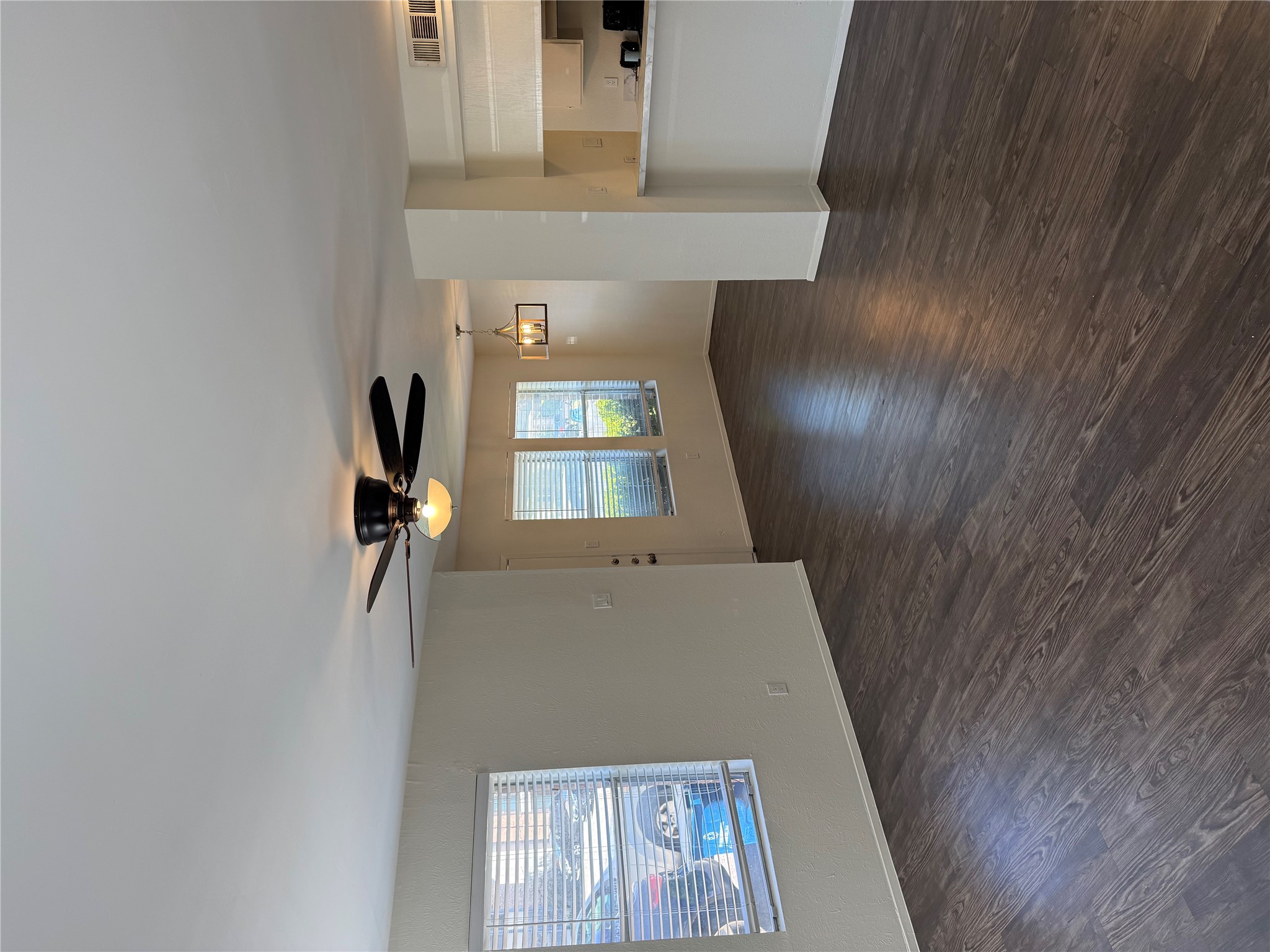11807 Alpheus Avenue, Unit B Austin, TX 78759 - Photo 2 of 16 Unfurnished living room featuring ceiling fan and dark wood-type flooring