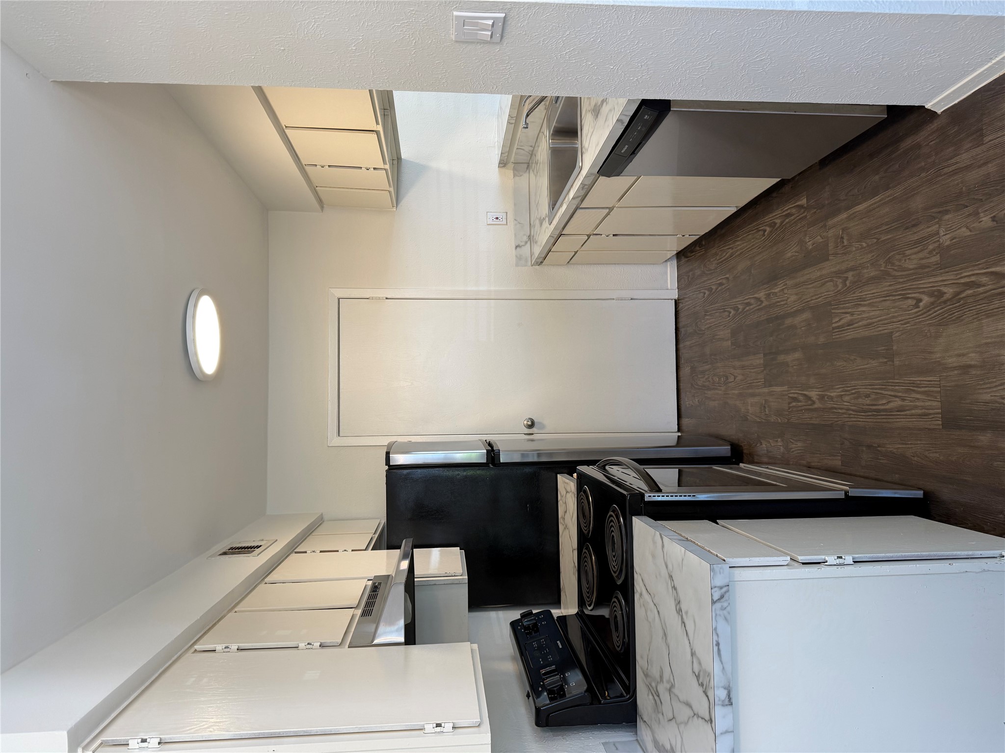 11807 Alpheus Avenue, Unit B Austin, TX 78759 - Photo 5 of 16 Kitchen with electric range oven, light countertops, dark wood-type flooring, and dishwasher