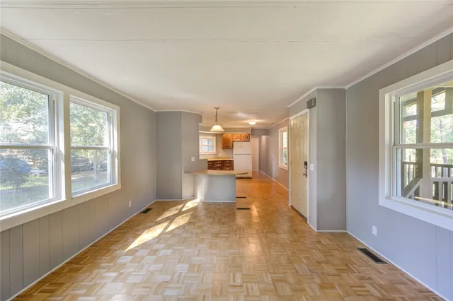 a view of a big room with wooden floor windows and a kitchen
