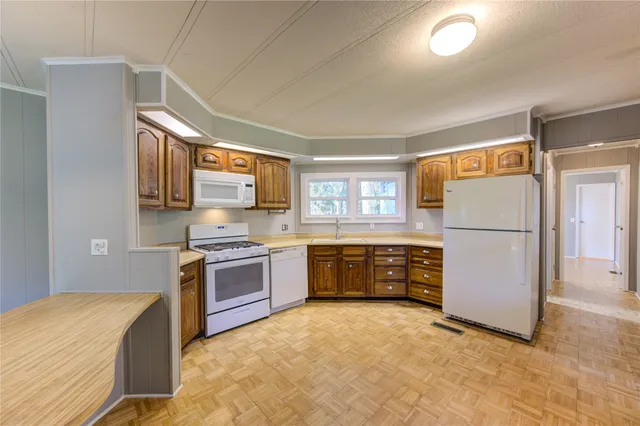 a kitchen with stainless steel appliances granite countertop a refrigerator a stove top oven and a sink