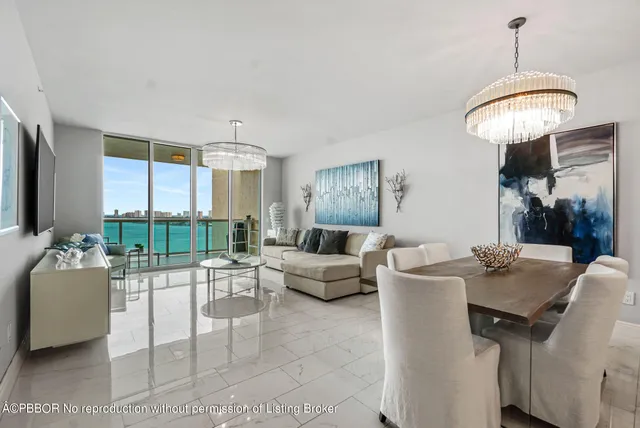 a living room with furniture a chandelier and a large window