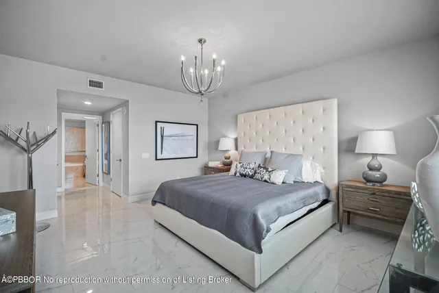 a bedroom with a large bed and a chandelier