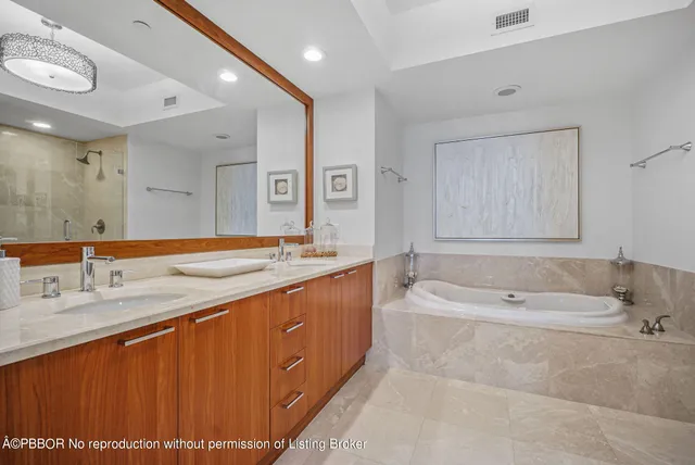 a spacious bathroom with a tub sink and mirror