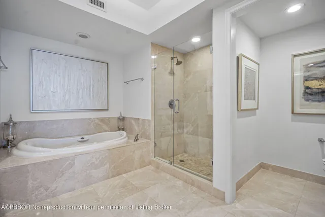 a bathroom with a tub shower and mirror