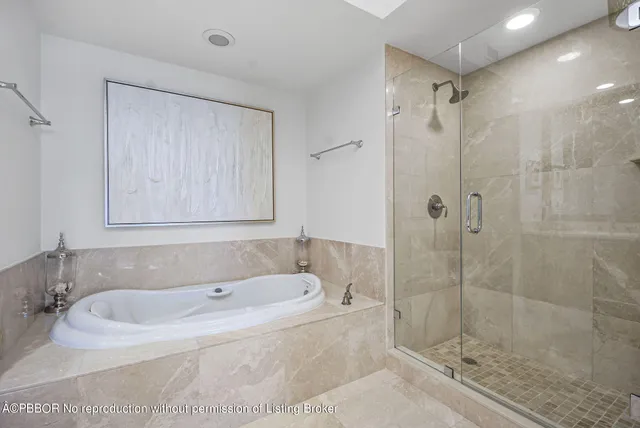 a bathroom with a tub shower sink and mirror