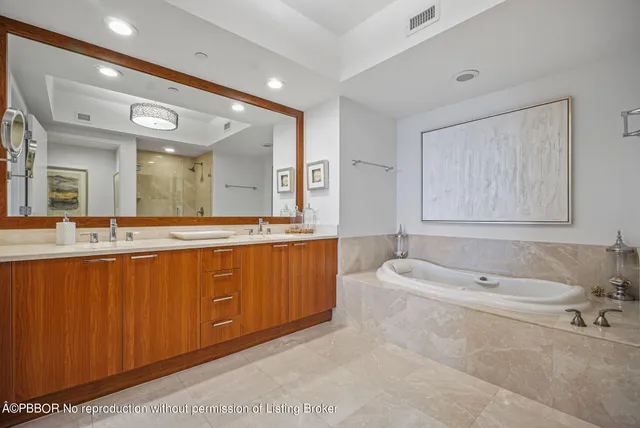 a spacious bathroom with a tub sink and mirror