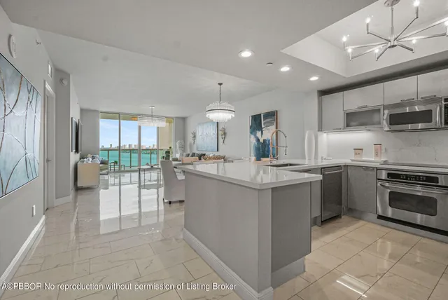 a large kitchen with kitchen island a large counter top space a sink stainless steel appliances and cabinets