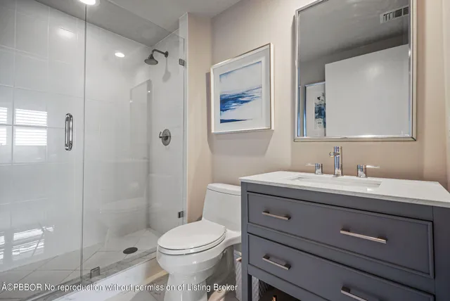 a bathroom with a granite countertop sink a toilet and shower