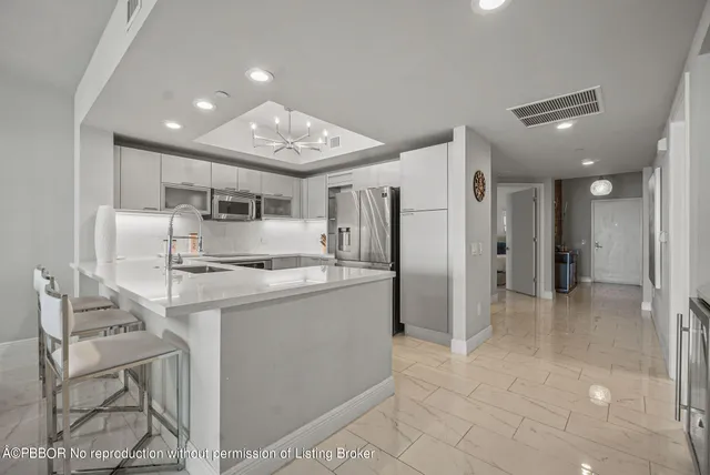 a kitchen with stainless steel appliances granite countertop a refrigerator and a stove top oven