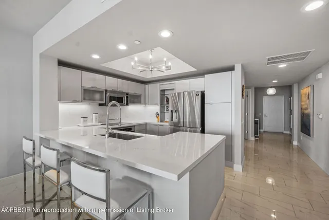 a kitchen with kitchen island a sink stove and refrigerator