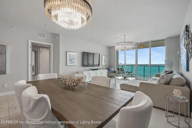 a living room with furniture chandelier and a large window