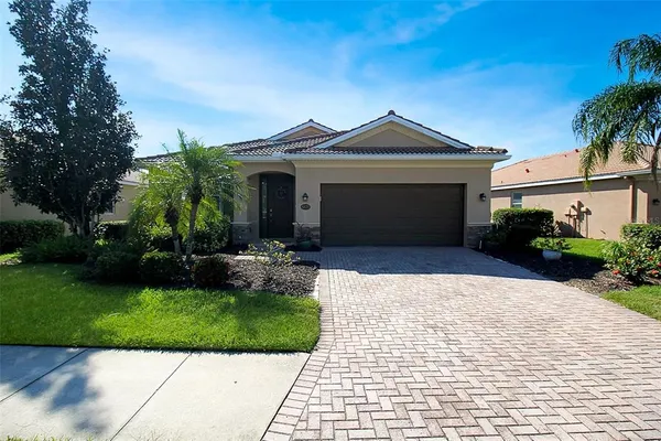 a front view of a house with a yard and potted plants