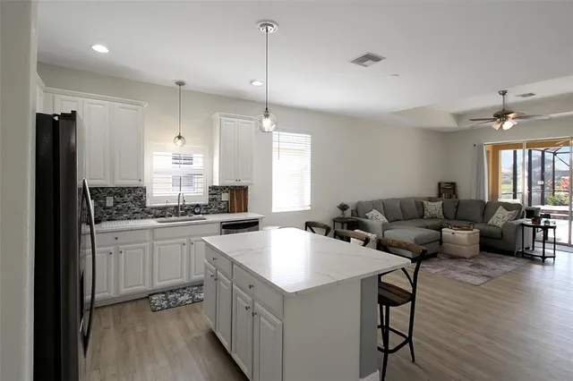 a kitchen with granite countertop a table chairs microwave and cabinets