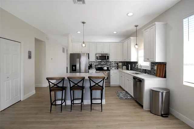 a kitchen with stainless steel appliances granite countertop a stove a sink and a microwave