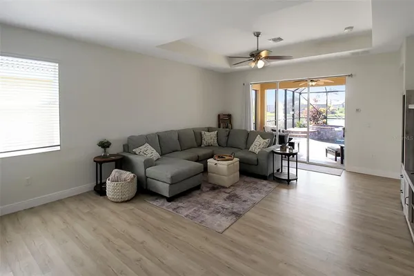 a living room with furniture a chandelier and a flat screen tv