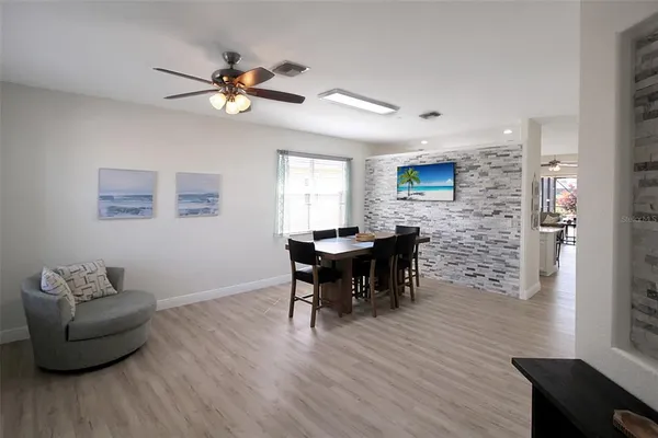 a dining room with furniture wooden floor and a flat screen tv