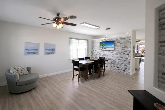 a dining room with furniture wooden floor and a flat screen tv